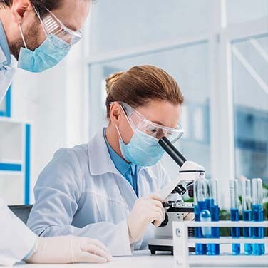 Des scientifiques regardant à travers un microscope Des scientifiques regardant à travers un microscope