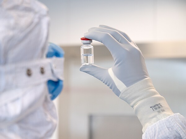 Scientist holding liquid sample with gloves on